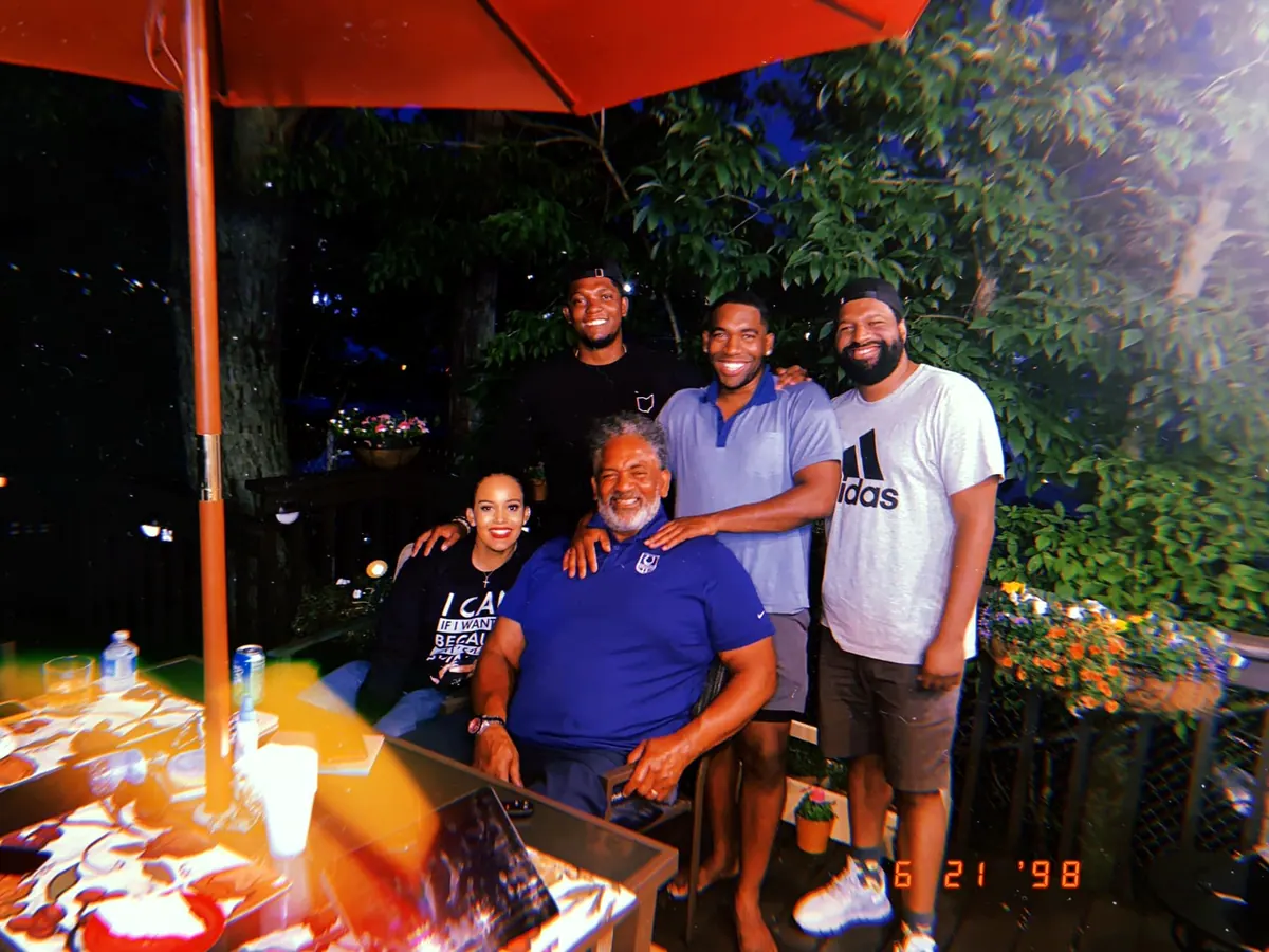 Chris Scott seated with his grown children around him.