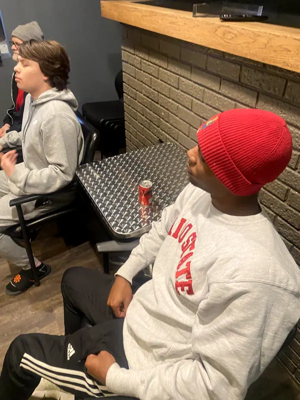 Boys sitting in a circle talking.