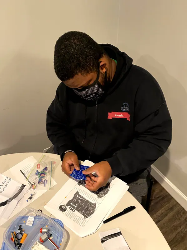 A boy concentrating on a hands-on project at a table.