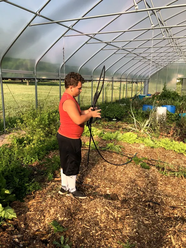 A boy working in a greenhouse.