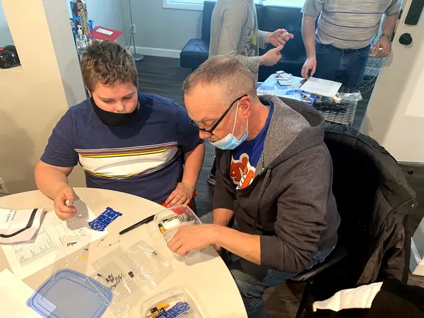 A mentor and a boy working on a project together.