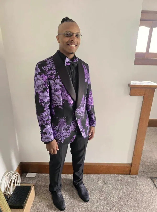A young man in a purple patterned suit jacket.