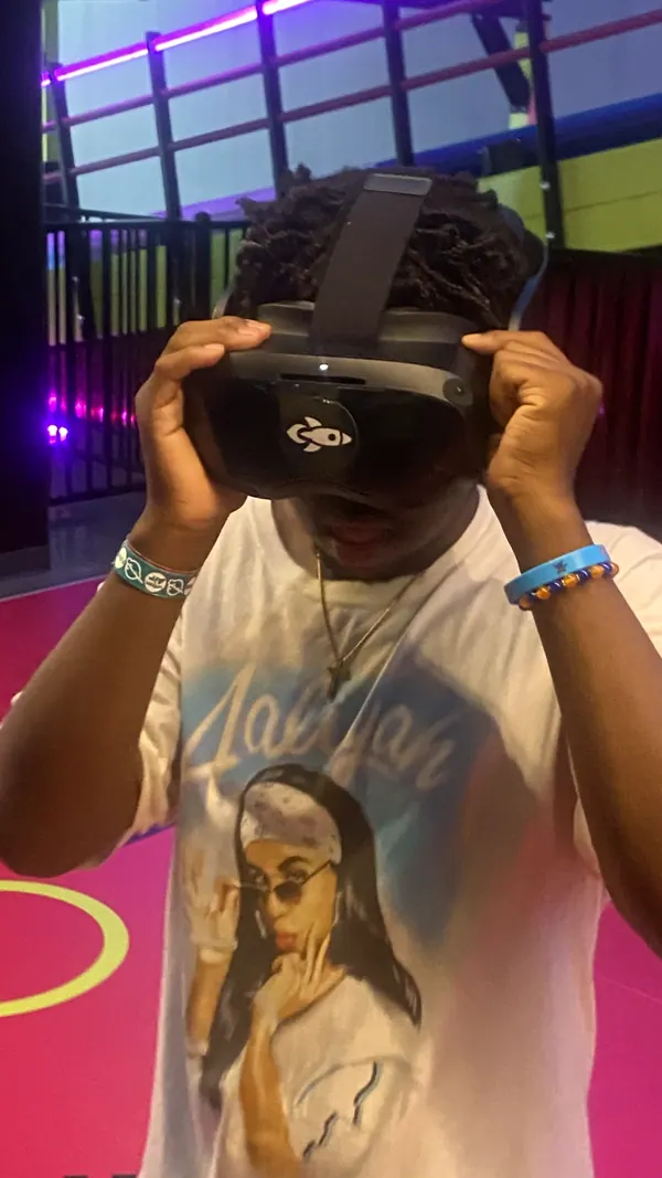 A boy trying a virtual reality headset on an outing.
